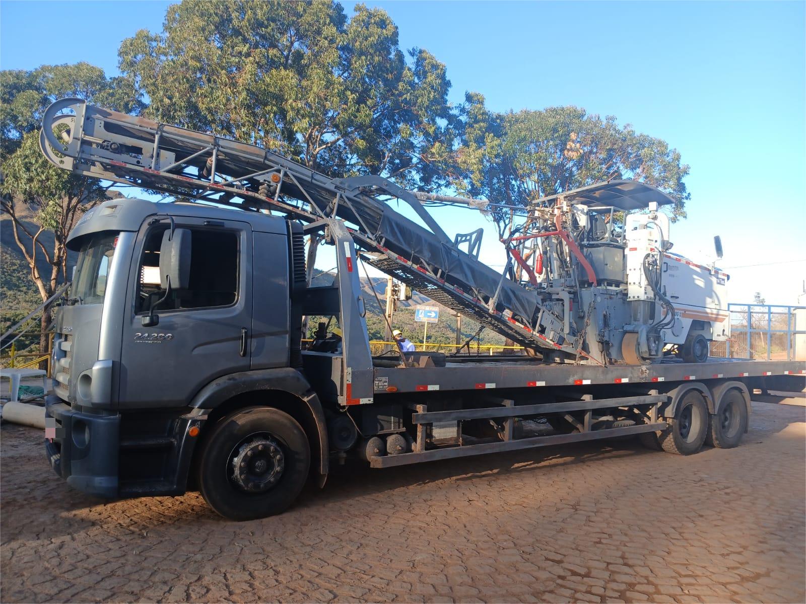 Caminhao prancha transportando equipamento pesado