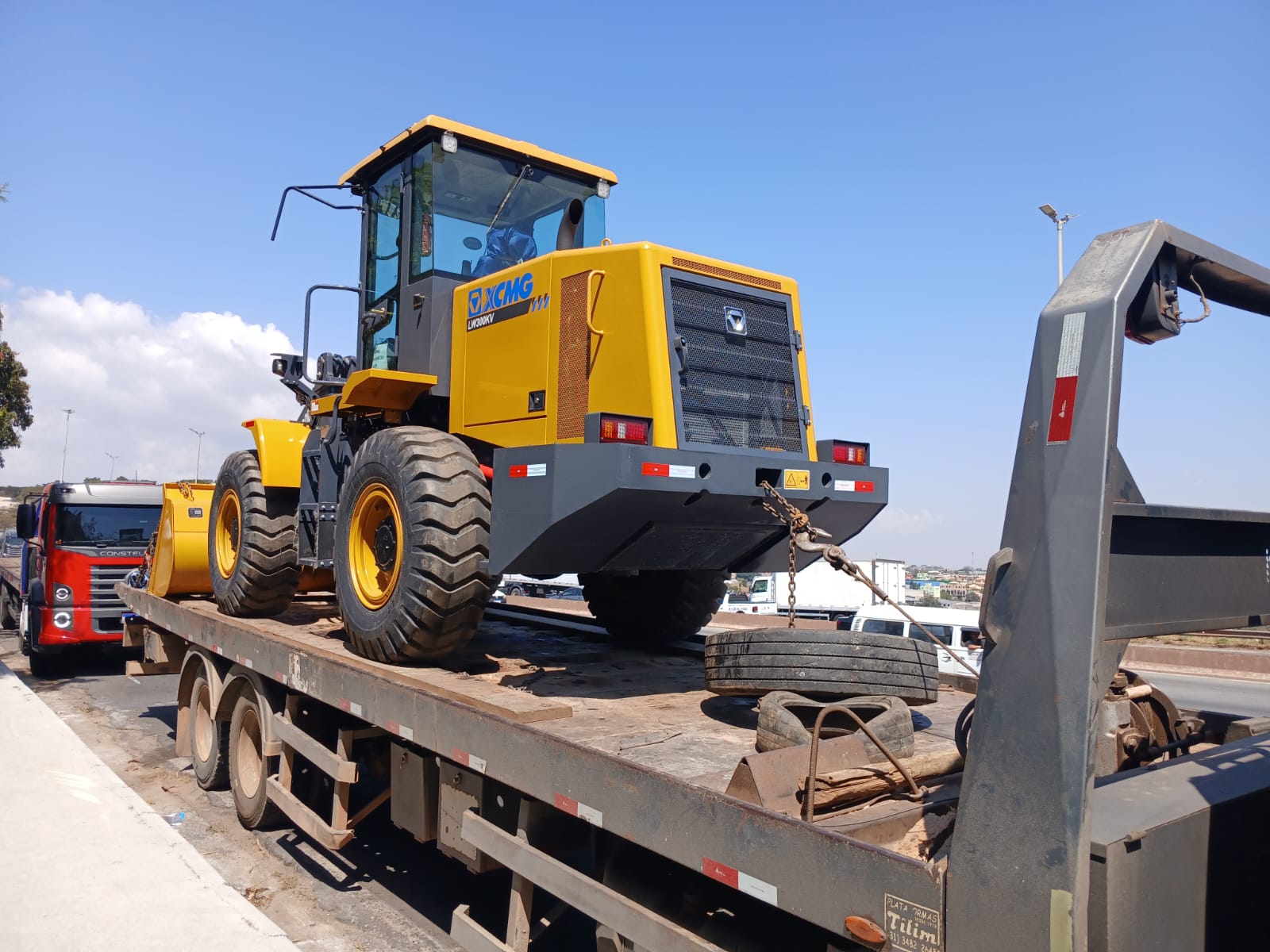 Caminhao prancha transportando maquina industrial