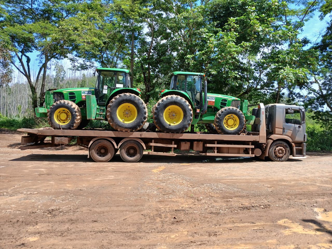 Caminhao prancha transportando maquina pesada