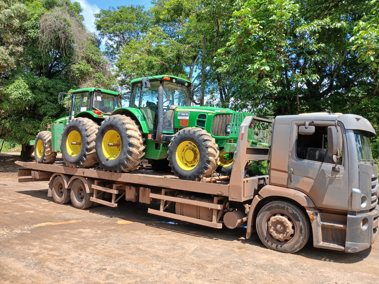 Caminhao prancha transportando equipamento agricola