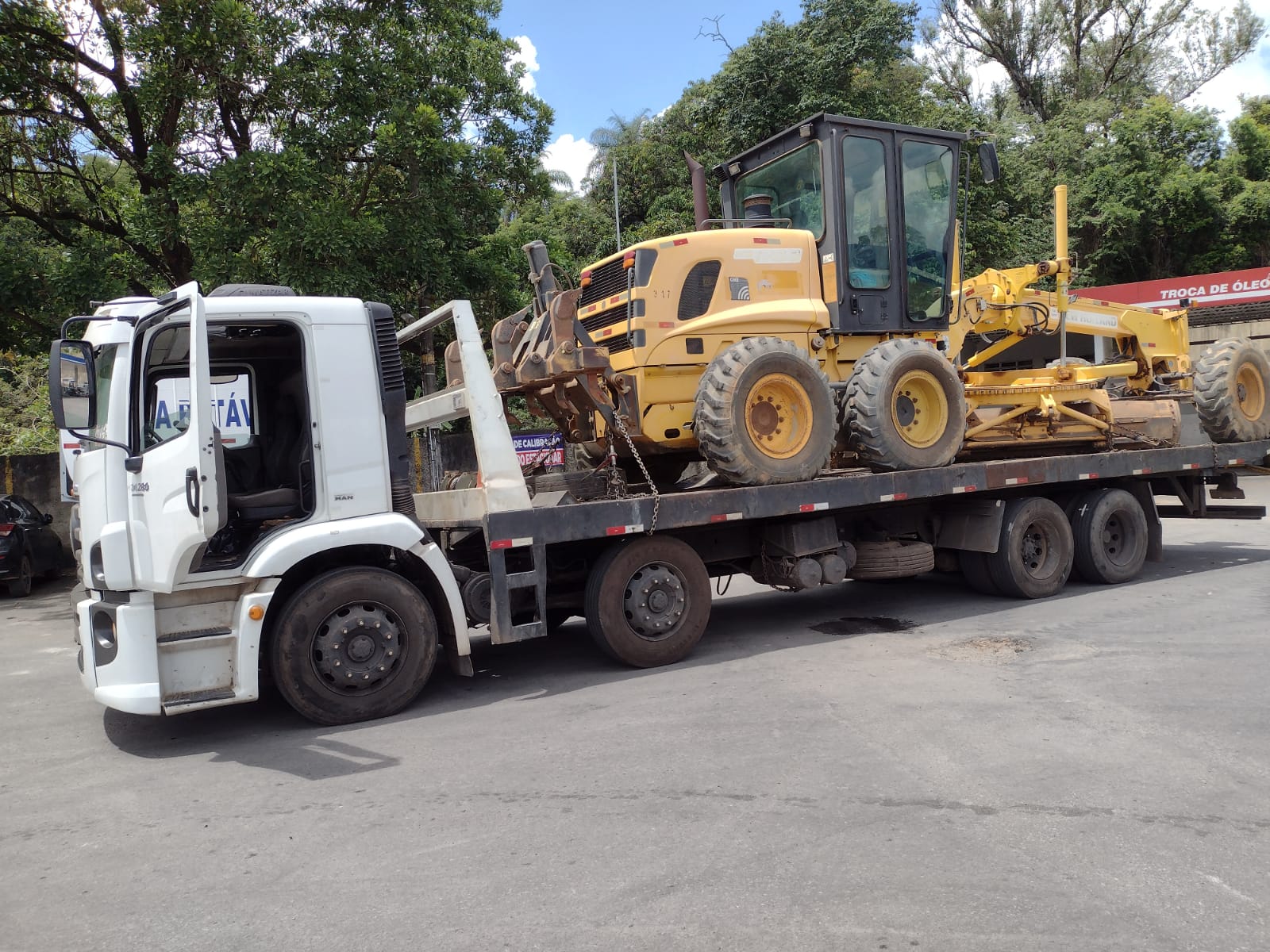 Caminhao prancha transportando motoniveladora