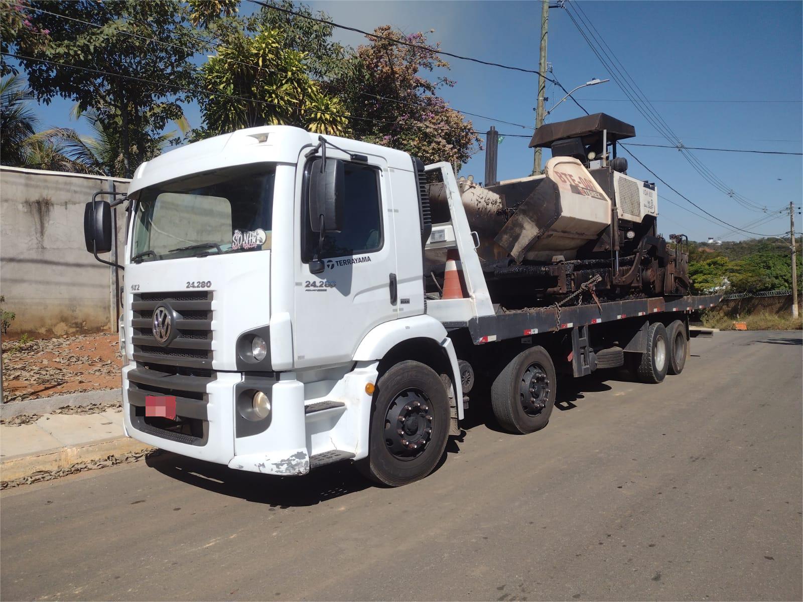 Caminhao prancha transportando perfuratriz amarela